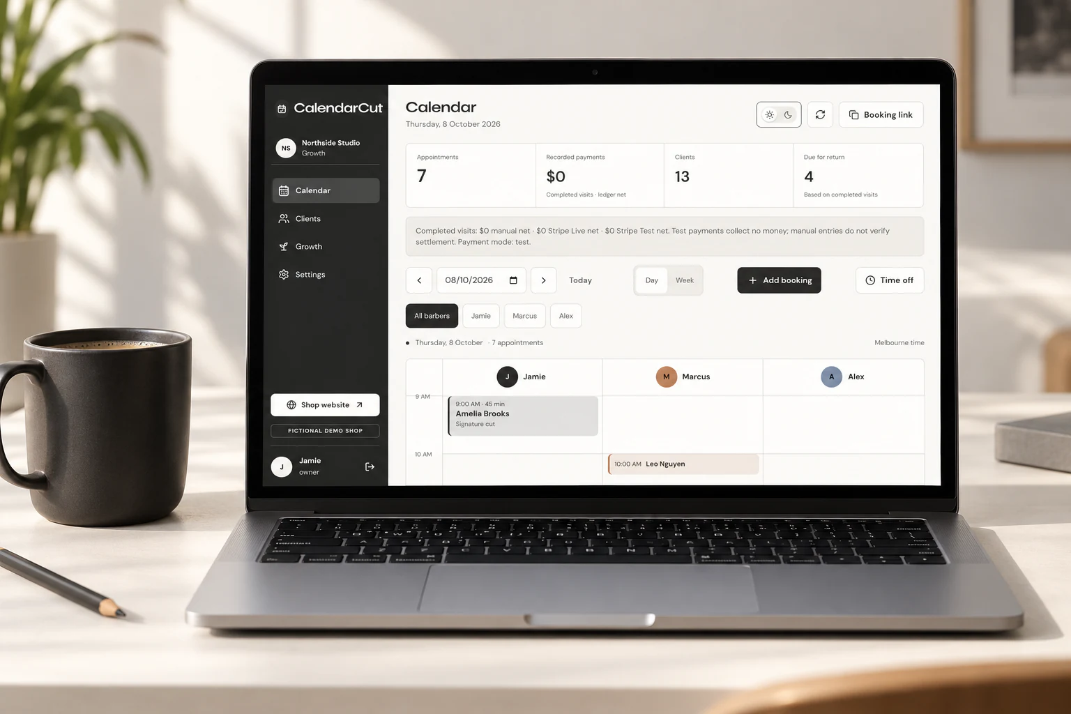 Laptop displaying CalendarCut's sample appointment diary beside a charcoal coffee cup